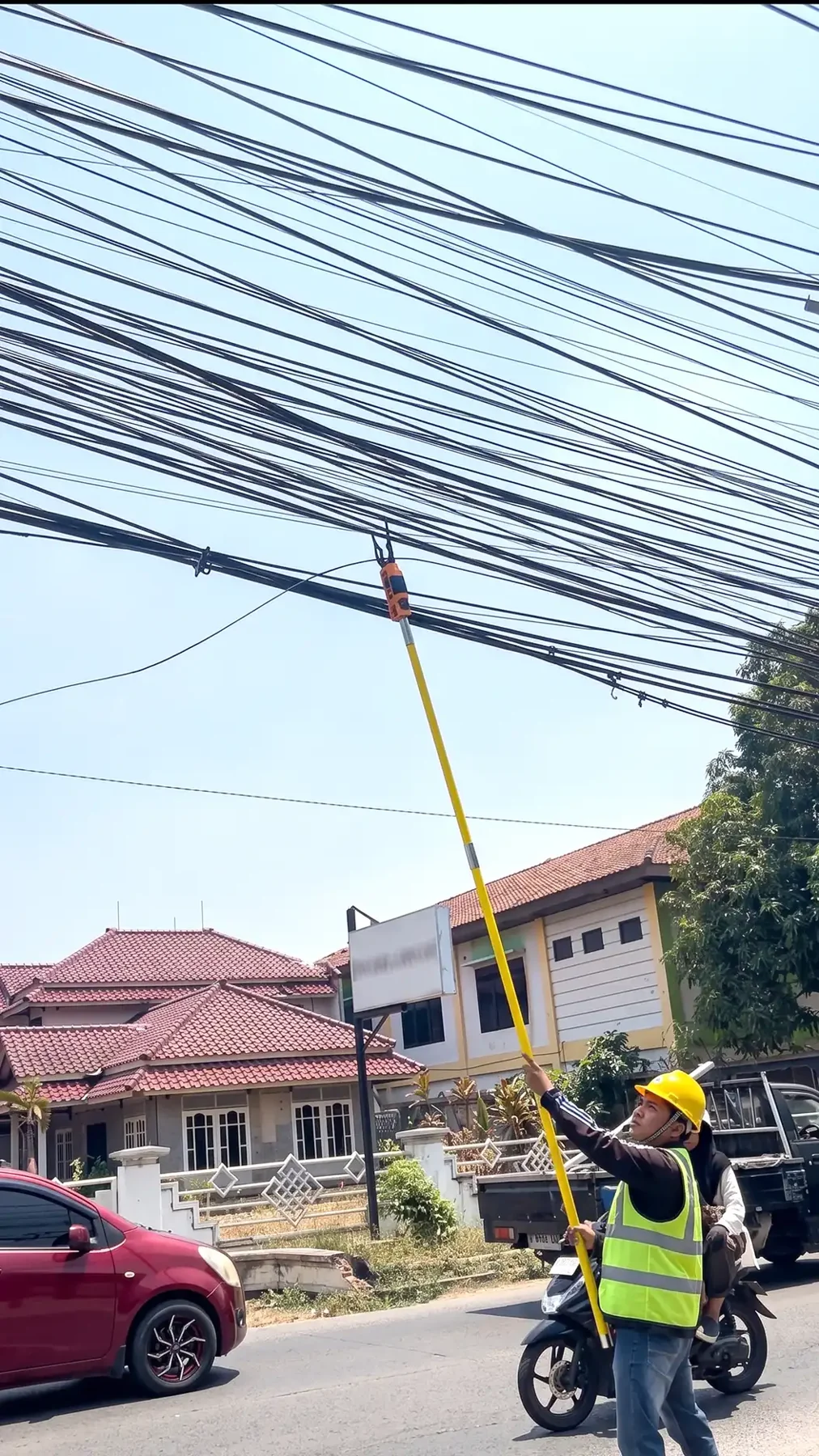 Tim merapikan kabel di wilayah layanan