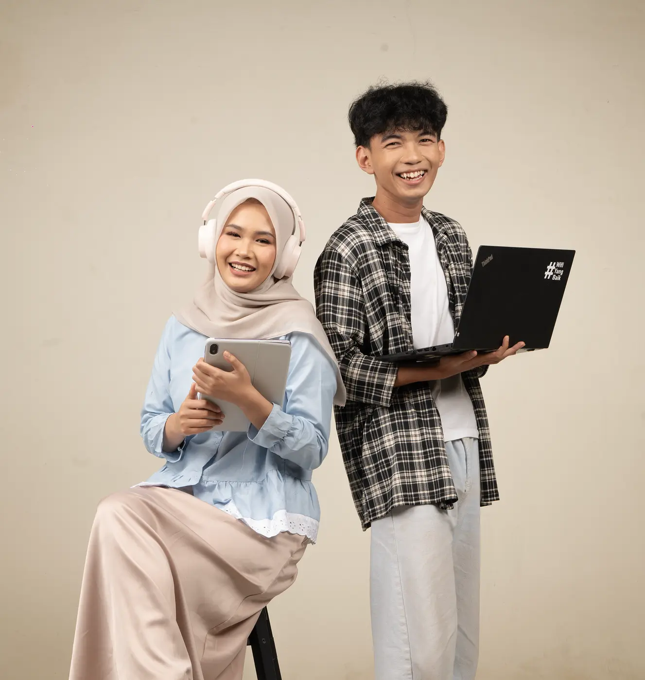 Dua orang tersenyum bersama perangkat digital