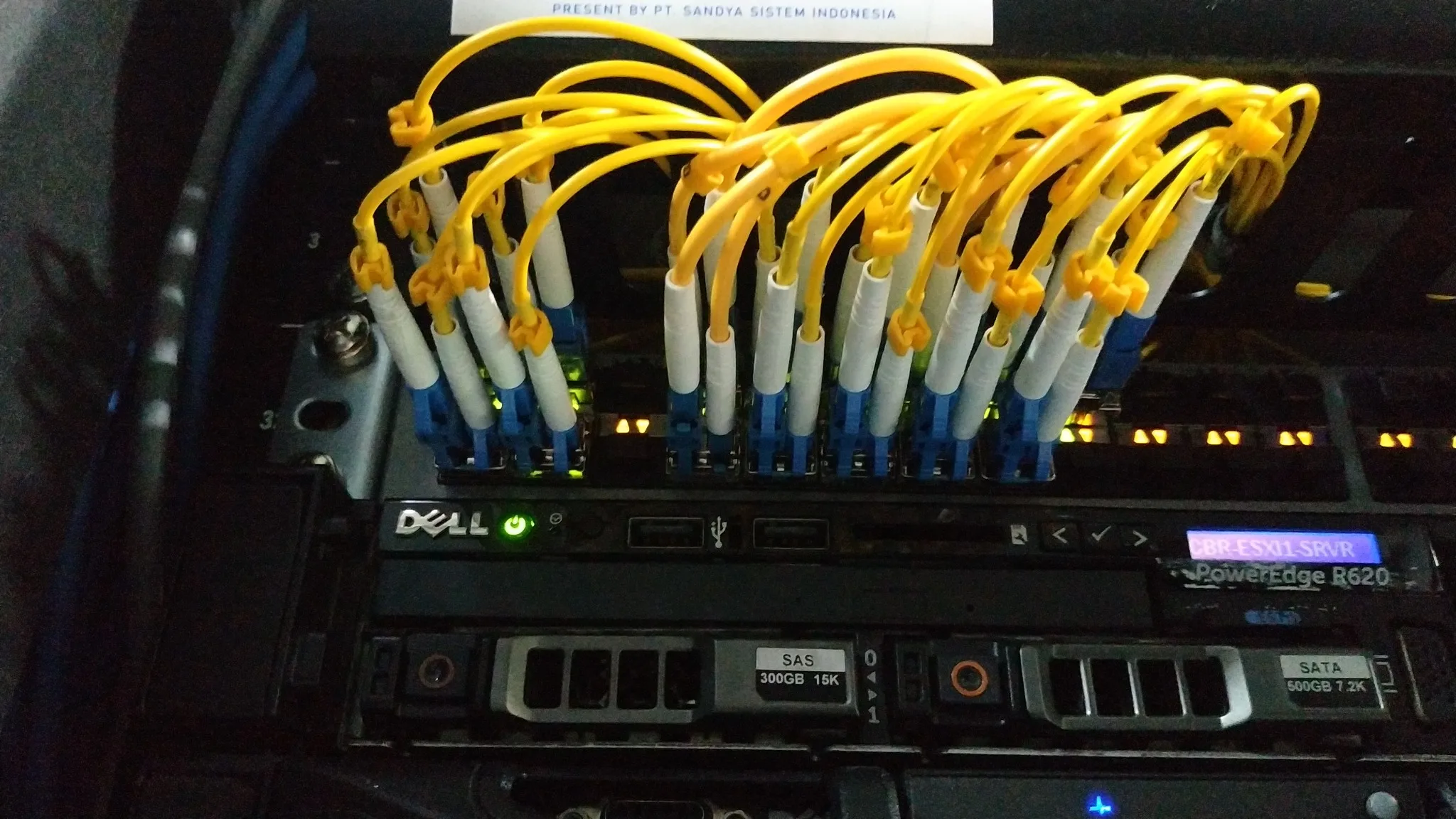 Kabel fiber terhubung pada panel perangkat jaringan Sandya